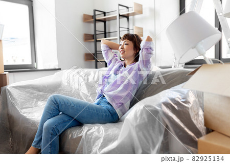 happy asian woman with stuff moving to new home happy asian woman with stuff moving to new home 82925134