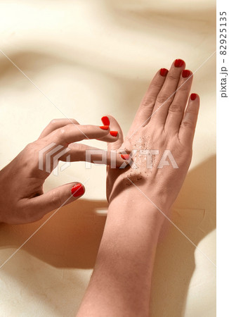 close up of hands applying natural scrub to skin 82925135