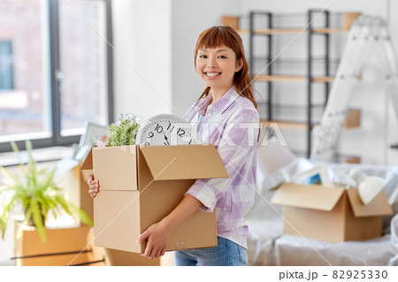 happy woman unpacking boxes and moving to new home 82925330