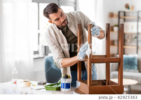 man cleaning old table surface with tissue man cleaning old table surface with tissue 82925363