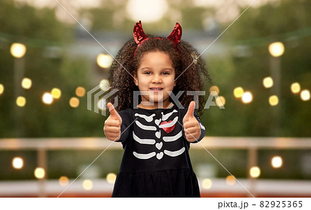 girl in black dress and devil's horns on halloween 82925365