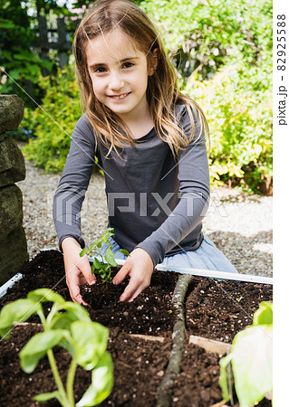 Smiling girl planting seedling Smiling girl planting seedling 82925588
