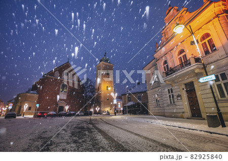 Poland, Subcarpathia, Rzeszow, Illuminated street with church in winter snowfall at night Poland, Subcarpathia, Rzeszow, Illuminated street with church in winter snowfall at night 82925840
