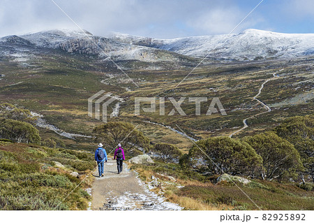 Australia, New South Wales, Two people hiking on trail at Charlotte Pass in Kosciuszko National Park 82925892