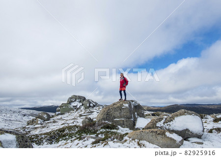 Australia, New South Wales, Man standing on rock at Charlotte Pass in Kosciuszko National Park 82925916