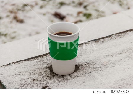 Cup of coffee on a snow covered table at winter 82927333