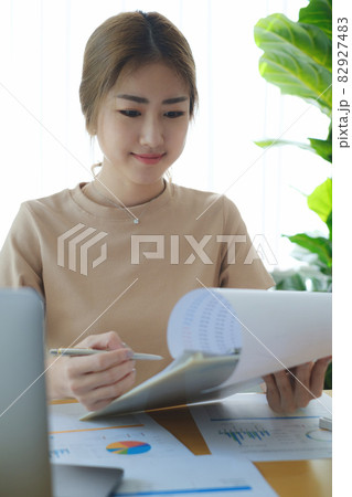 Business woman hand holding pen and data document, account or saving money or insurance concept. Business woman hand holding pen and data document, account or saving money or insurance concept. 82927483