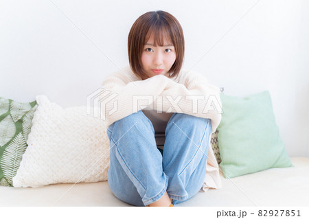膝を抱えてこちらを見つめる女性 膝を抱えてこちらを見つめる女性 82927851