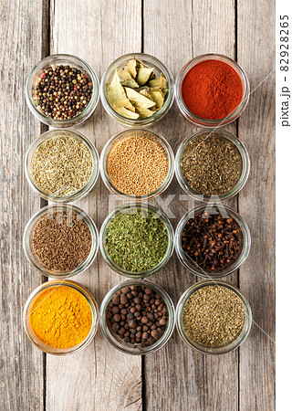 Various types of seasonings in bowls. Collection of seasonings on wooden background 82928265
