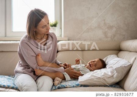 The little boy cry because of the high temperature. First year of life. Sick child at home with high 82931677