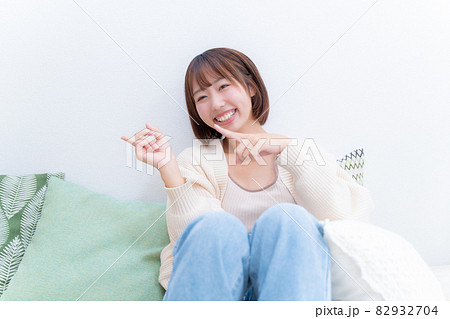 両手で左側を指差す笑顔の女性 両手で左側を指差す笑顔の女性 82932704