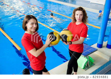 Two erobics trainers in front of the pool. Two erobics trainers in front of the pool. 82934881