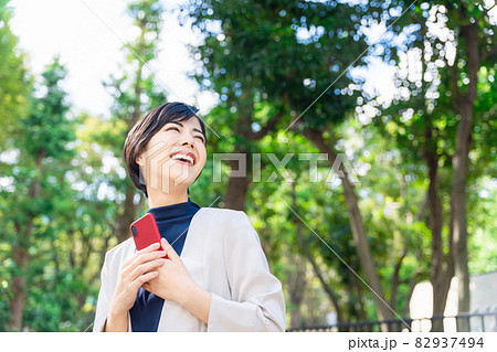 街でスマホを使う女性 82937494
