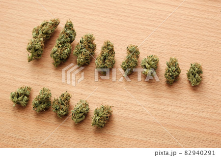 Marijuana outdoor buds in row on wooden background Marijuana outdoor buds in row on wooden background 82940291