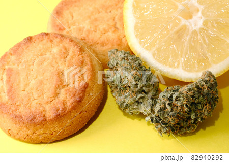 Cookies with CBD oil. Marijuana buds on yellow background Cookies with CBD oil. Marijuana buds on yellow background 82940292