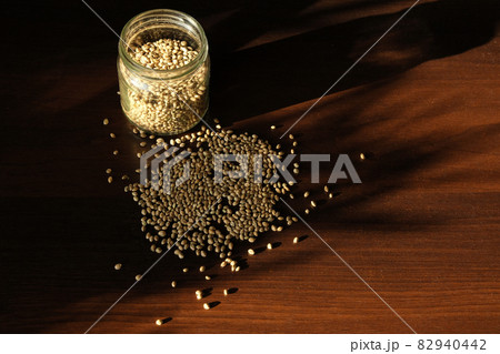 Marijuana seed's storage. Cannabis seeds on brown wooden background. Marijuana seed's storage. Cannabis seeds on brown wooden background. 82940442