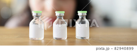 Woman looks at vaccine bottle and decides which one to choose 82940899