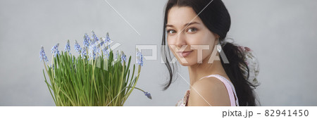 Woman Holding Bouquet of Flowers in Hands Indoors 82941450
