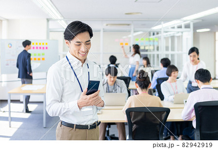 オフィスでスマホを見るビジネスマン オフィスでスマホを見るビジネスマン 82942919