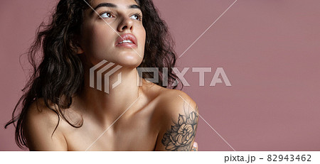 Cropped close-up portrait of young beautiful woman thoughtfully looking up isolated over pink background. Flyer Cropped close-up portrait of young beautiful woman thoughtfully looking up isolated over pink background. Flyer 82943462