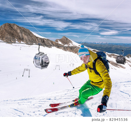 Skier skiing downhill during sunny day in high mountains, Kaprun glacier- Zell am see, Austria Skier skiing downhill during sunny day in high mountains, Kaprun glacier- Zell am see, Austria 82945536