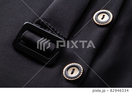 Black stylish clothes with buttons and a belt, background. Dress for woman, macro, material Black stylish clothes with buttons and a belt, background. Dress for woman, macro, material 82946334