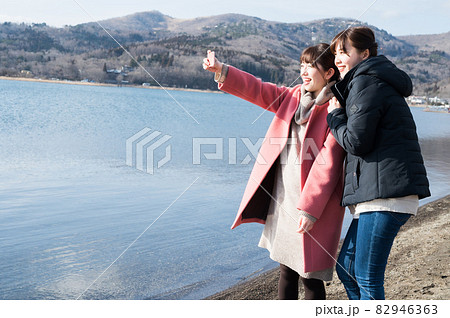 冬の山中湖畔で仲良く自撮り撮影する二人の女性 82946363