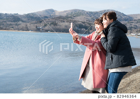 冬の山中湖畔で仲良く自撮り撮影する二人の女性 82946364