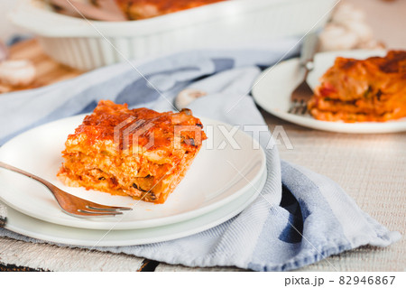 Piece of tasty hot lasagna served with on a white plate. Italian cuisine, menu, recipe. Homemade meat lasagna 82946867