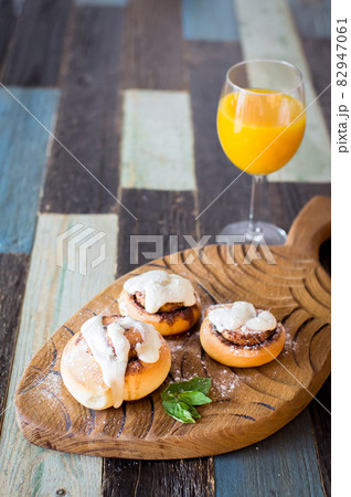 Homemade buns with cinnamon and a glass of juice. High quality photo. 82947061