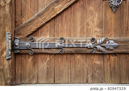 Beautiful handmade forged door hinge, close-up. Ancient architecture, gothic Beautiful handmade forged door hinge, close-up. Ancient architecture, gothic 82947329