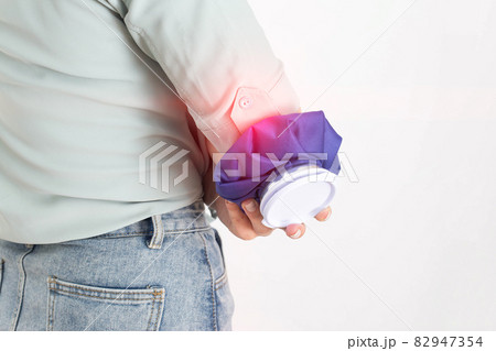 A girl holds a medical ice bag to eliminate edema after a bruised elbow. Cold joint treatment 82947354