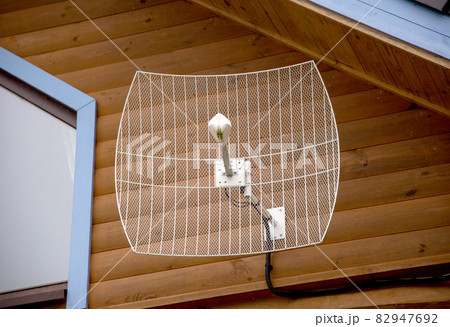 Parabolic antenna for amplifying the signal of cellular communication and the Internet installed in a country house. Strengthening the 4G and 5G Internet signal in the country, close-up Parabolic antenna for amplifying the signal of cellular communication and the Internet installed in a country house. Strengthening the 4G and 5G Internet signal in the country, close-up 82947692