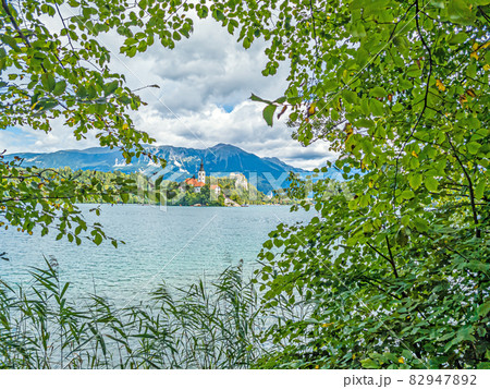 View of Bled castle and pilgrimage church with the Alps in the background in Slovenia during the day View of Bled castle and pilgrimage church with the Alps in the background in Slovenia during the day 82947892