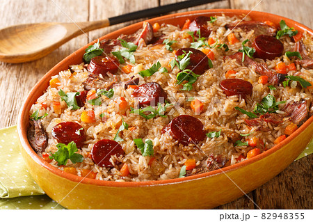 Portuguese duck rice arroz de pato cooked with red wine, onion, carrot and chorizo close up in the baking dish. Horizontal 82948355