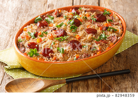 Authentic Arroz de pato duck rice is a traditional recipe from Portugal cooked with red wine, onion, carrot and chorizo close up in the baking dish. Horizontal 82948359