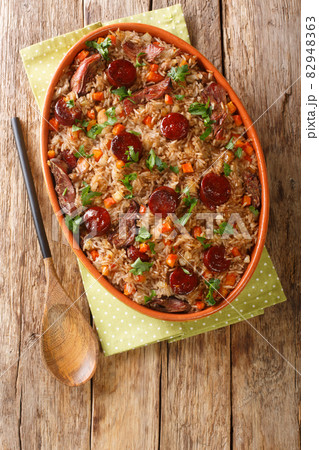 Arroz de Pato Portuguese Style Duck Rice with onion, carrot and chorizo close up in the baking dish. Vertical top view 82948363