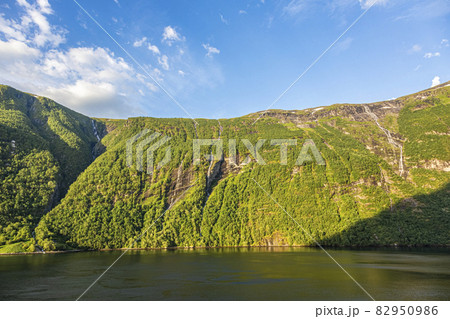 Impression from cruise ship on the way through Geiranger fjord in Norway at sunrise in summer 82950986