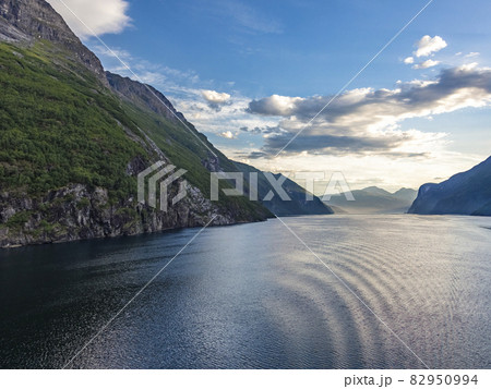 Impression from cruise ship on the way through Geiranger fjord in Norway at sunrise in summer 82950994