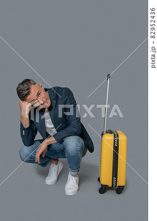 Bored man near suitcase waiting for flight 82952436