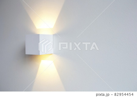 A glowing modern aluminum led lamp on white wall in retro home decoration with copy space. Luxury design A glowing modern aluminum led lamp on white wall in retro home decoration with copy space. Luxury design 82954454