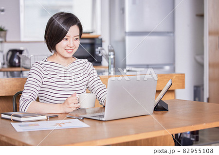 テレワーク中に気分転換にコーヒーを飲む若い女性 テレワーク中に気分転換にコーヒーを飲む若い女性 82955108
