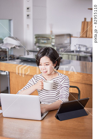 テレワーク中に気分転換にコーヒーを飲む若い女性 82955110