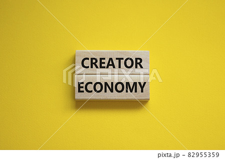 Creator economy symbol. Wooden blocks with words Creator economy on beautiful yellow background, copy space. Business and creator economy concept. Creator economy symbol. Wooden blocks with words Creator economy on beautiful yellow background, copy space. Business and creator economy concept. 82955359
