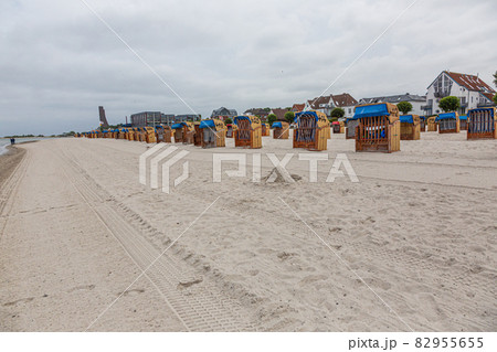 Roofed wicker beach chairs at beach of German village Laboe in summer 82955655