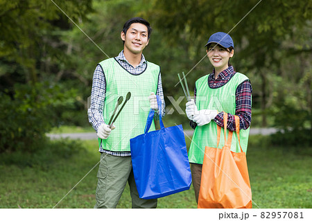 ゴミ拾いをする若い男女 82957081