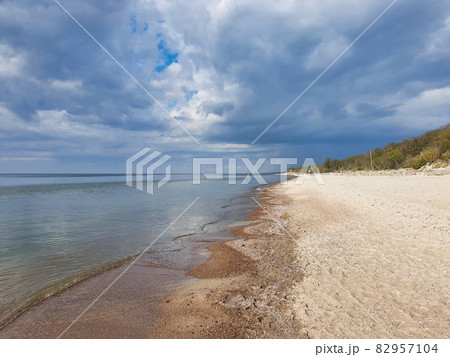 Baltic sea beach with calm waves and cloudy sky Baltic sea beach with calm waves and cloudy sky 82957104