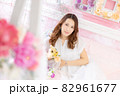 ピンクのお部屋でお花に囲まれた女性 82961677