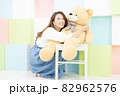 大きなクマのぬいぐるみを抱っこする女性 82962576