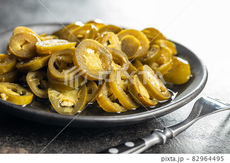 Pickled sliced jalapeno. Green jalapeno peppers Pickled sliced jalapeno. Green jalapeno peppers 82964495